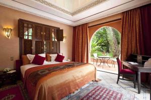 马拉喀什居萨阿迪马拉喀什宫殿度假酒店的一间卧室配有一张床、一张书桌和一个窗户。