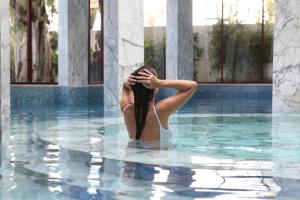 马拉喀什居萨阿迪马拉喀什宫殿度假酒店的女人站在游泳池里