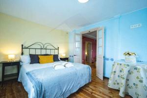 比利亚维西奥萨Casa PedroArias Rodiles的蓝色卧室,配有带毛巾的床
