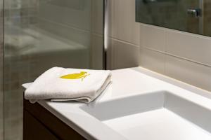 圣塔克里斯蒂纳阿鲁Apartaments Tee & Sea的浴室配有白色水槽和毛巾