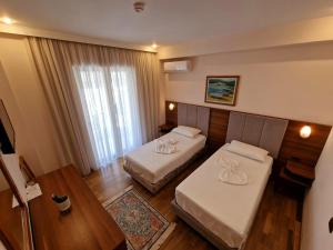 萨兰达考尼亚酒店的酒店客房设有两张床和一张桌子。