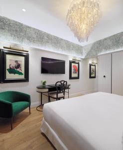 塞维利亚H10柯里基多精品酒店 的一间卧室配有一张床、一张桌子和一台电视。