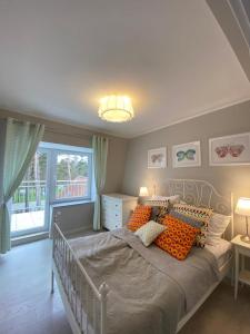波别罗沃Apartamenty Silence Blue Baltic的一间卧室配有一张带橙色枕头的大床