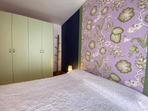 明乔河畔的瓦雷奇奥Appartamenti di Andrea的一间卧室配有一张紫色墙壁的床