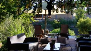 库鲁曼Cunningham Cottage Guest House的庭院配有桌椅和遮阳伞。