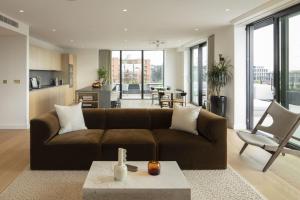 伦敦Modern Apartments at Enclave located in Central London的客厅配有棕色沙发和桌子