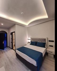 库萨达斯艾婷萨瑞酒店的一间卧室配有一张带蓝色枕头的大床
