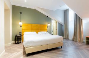 热那亚Hotel Astoria的一间卧室配有一张带黄色床头板的大床