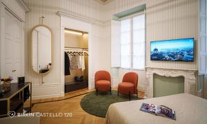 卡利亚里Albergo Diffuso Birkin Castello的一间卧室配有一张床、两把椅子和镜子