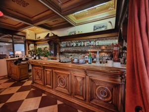 萨路特德沃克吕兹Logis Hôtel Restaurant Le Louvre的餐厅内的酒吧设有大型木台