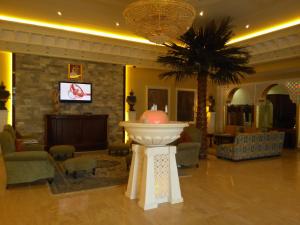 沙迦沙迦国际机场酒店的大堂拥有棕榈树和大型喷泉
