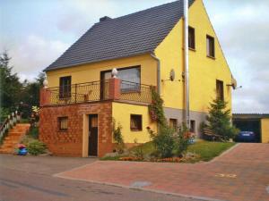 巴特Apartment Kenz-Küstrow的街道上带阳台的黄色房屋