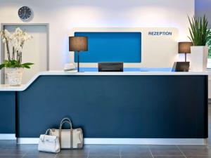 乌尔姆乌尔姆市宜必思快捷酒店的办公室里的一个前台,有蓝色的墙壁