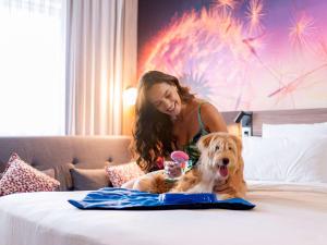 索罗卡巴索罗卡巴诺富特酒店的女人和狗一起坐在床上