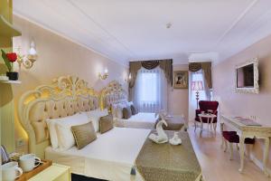 伊斯坦布尔Edibe Sultan Hotel的卧室配有一张白色大床和一张书桌