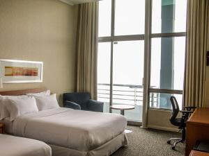 蒙特港Novotel Puerto Montt的酒店客房设有两张床和窗户。