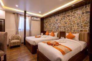 加德满都Airport Himalaya Boutique Hotel的酒店客房,配有两张床和椅子