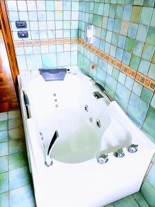 下卡斯泰卢乔La quercia di Massena的带浴缸的浴室和瓷砖墙