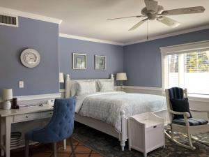 恩西尼塔斯凯特斯坦顿住宿加早餐旅馆的一间卧室设有蓝色的墙壁和一张带桌椅的床。