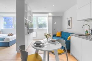 伦敦Livestay-Modern Apartments Next To Wembley Stadium的厨房以及带桌椅的起居室。