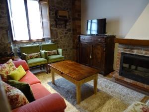 Llerices科拉丁乡村民宿的带沙发、桌子和壁炉的客厅