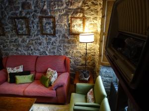 Llerices科拉丁乡村民宿的客厅配有粉红色的沙发和椅子