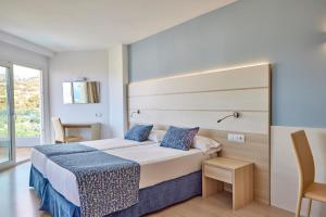 波塔尔斯诺斯Tomir Portals Suites - Adults Only的酒店客房设有一张床和一个大窗户