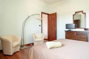 科尔萨诺Tenuta De Masi的一间卧室配有一张床、两把椅子和镜子
