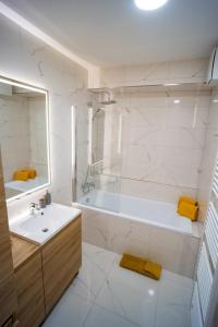 普雷绍夫Po City Newly Built Apartment的白色的浴室设有浴缸和水槽。
