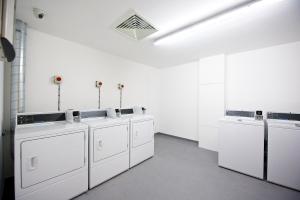伦敦Staycity Aparthotels London Greenwich High Road的白色洗衣房配有白色的洗涤器和水槽