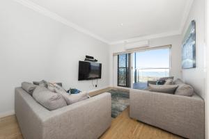 兰斯林Oceans View - Luxury Apartment with ocean views的客厅配有两张沙发和一台电视机