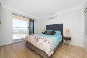 兰斯林Oceans View - Luxury Apartment with ocean views的一间卧室设有一张床和一个大窗户