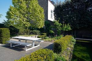 布鲁日Havenhuis Brugge的花园中间的白色野餐桌