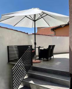 温科夫齐Apartman Star #1的一个带桌子和遮阳伞的庭院