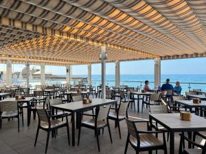 内尔哈珍珠码头酒店的一间带桌椅的海景餐厅