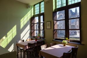 根特埃珀领克旅舍的餐厅设有桌椅和窗户。