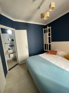 奥斯坦德Hotel HEB的一间卧室设有一张床和蓝色的墙壁