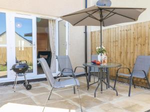 比迪福德Pebble Bay的庭院配有桌椅和遮阳伞。