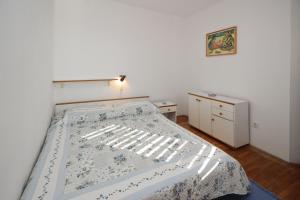 普纳特Apartman Nada的一间卧室配有一张带蓝白色毯子的床