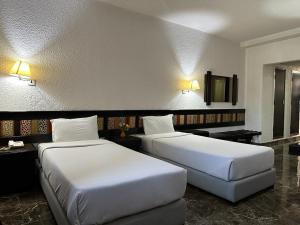 拉巴特Ourida Urban Hotel Rabat的配有两张床垫的酒店客房内的两张床