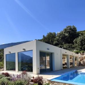 ChaliotataVilla Iremia Des vacances waouw en toute sérénité!的一座白色的房子,前面设有一个游泳池