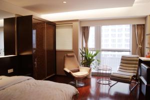 南京Kaibin Apartment- Nanjing University Branch的卧室配有床、椅子和窗户。