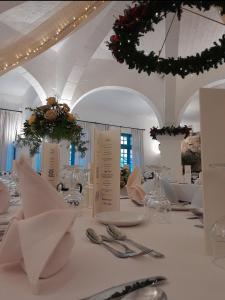 沙拉聚宝盆酒店的白色的用餐室配有白色的桌子和银器