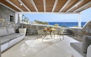 卡拉法蒂斯VLIA Mykonos的一个带桌椅的庭院和大海