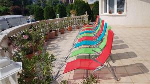 根尼斯迪亚斯Pihenés Háza-Relax Apartmanhaus的坐在庭院里的一排五颜六色的椅子