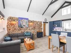 霍尔斯沃西Strawberry Bank - Kingfisher的带沙发和砖墙的客厅