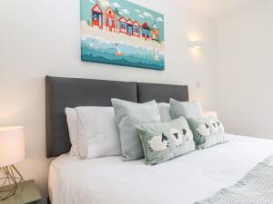 霍尔斯沃西Strawberry Bank - Kingfisher的卧室配有一张白色床,墙上挂有绘画作品