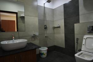卡尔佩特塔ARAKKAL GUESTHOUSE的一间带水槽、卫生间和镜子的浴室
