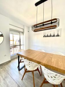 圣费尔南多Apartamento en el centro San Fernando Cadiz.的一间带木桌和椅子的用餐室