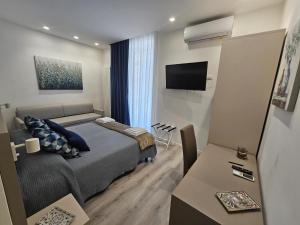 卡塔尼亚City Rooms Katane的一间卧室配有一张床、一台电视和一张桌子